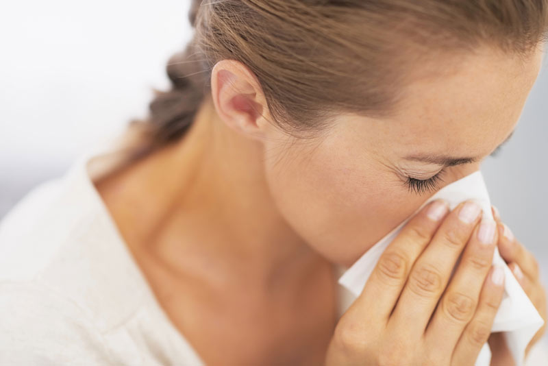 Woman sneezing from poor air quality