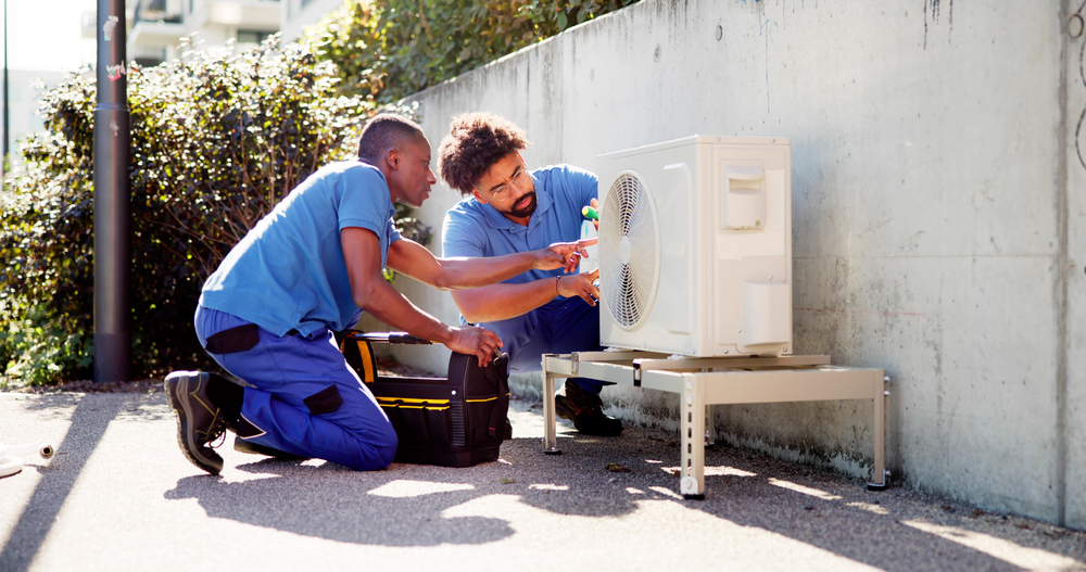 Two technicians working on an air conditioning sytem