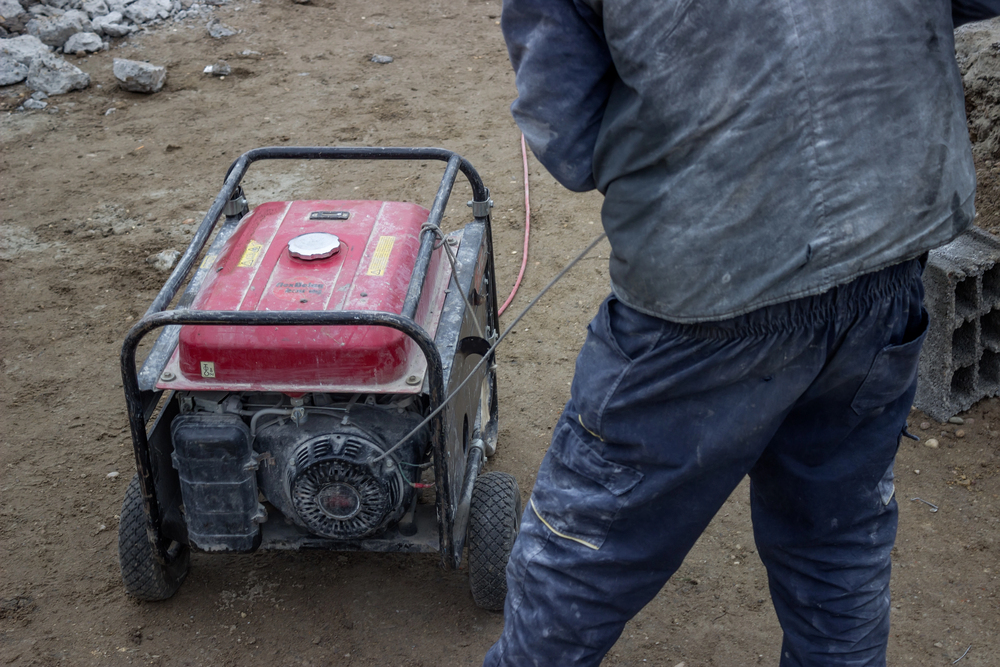 Man starting portable gas generator