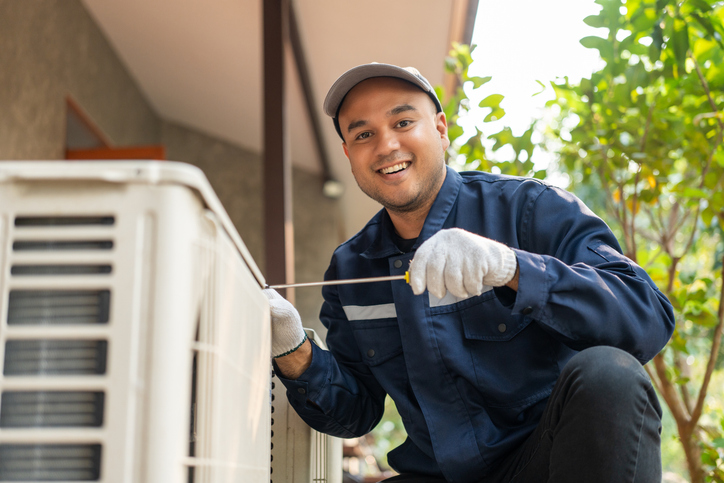 HVAC technician working on air conditioner